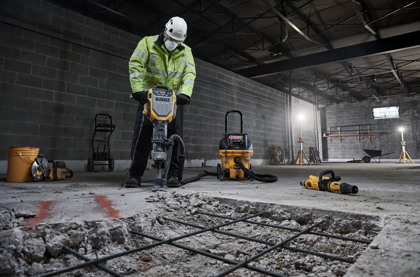 DEWALT D25966, D25966-B2 auf Baustelle gezeigt, Betonboden brechend mit Sicherheitsausrüstung.