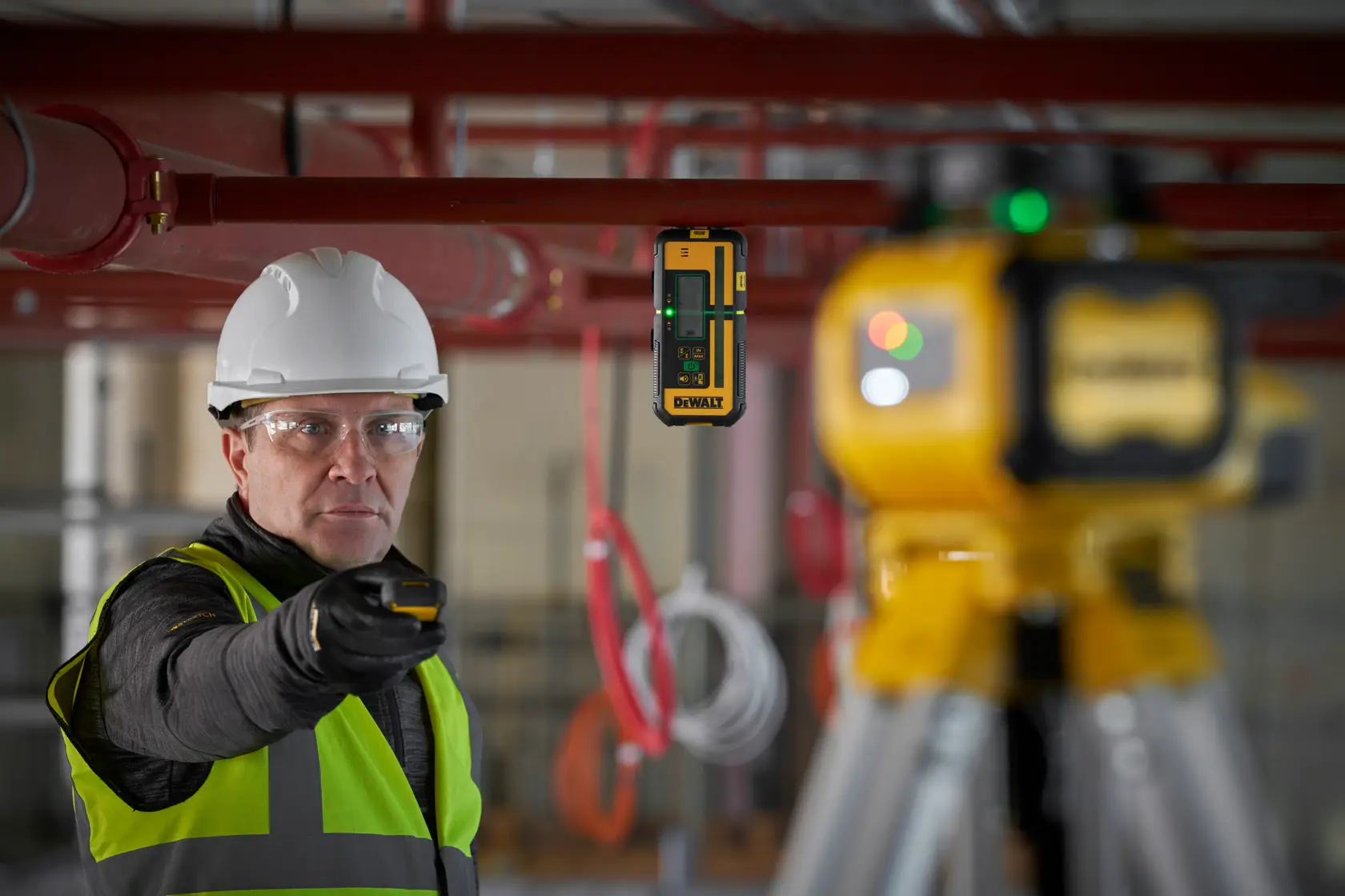 DEWALT DCLE15221G-QW, DCLE15221G Laser, Stativ und Arbeiter mit Schutzkleidung auf Baustelle.