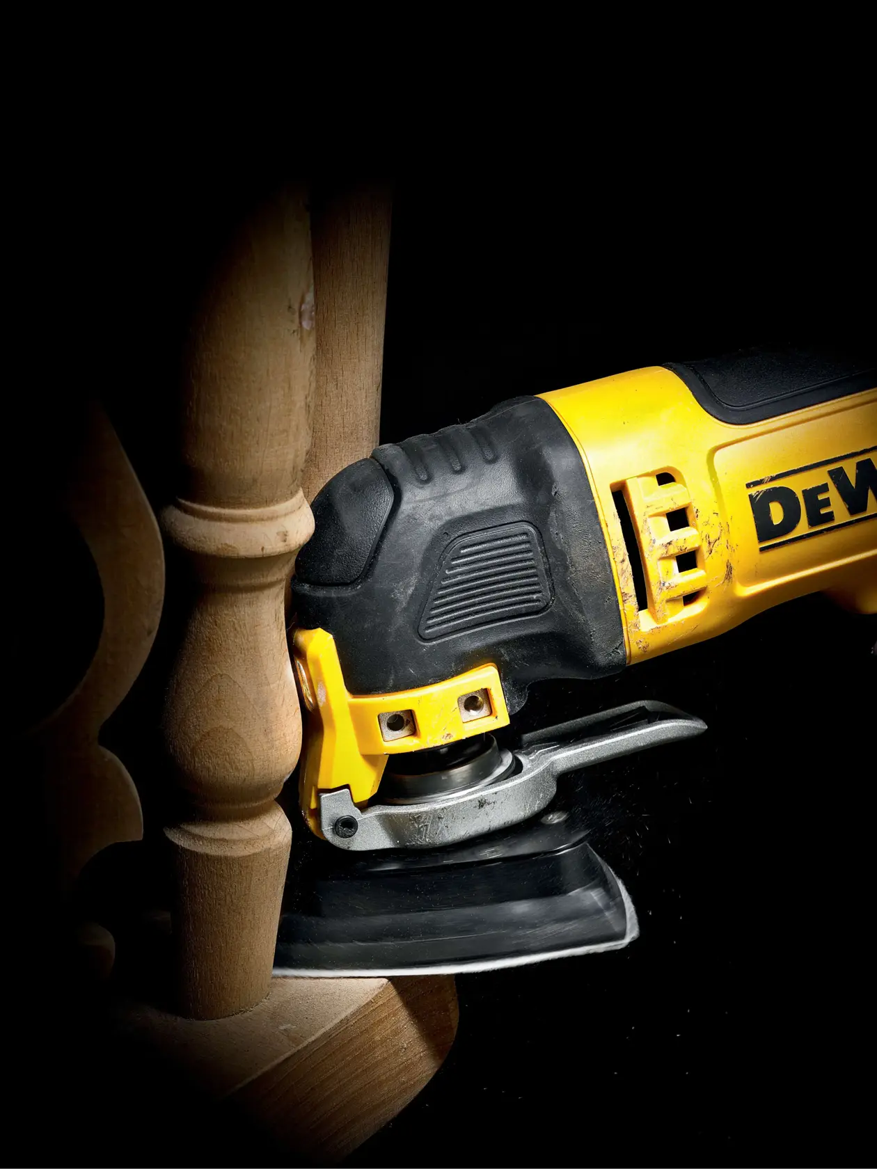 Multitool DEWALT lijando mueble de madera en primer plano, muestra trabajo preciso.
