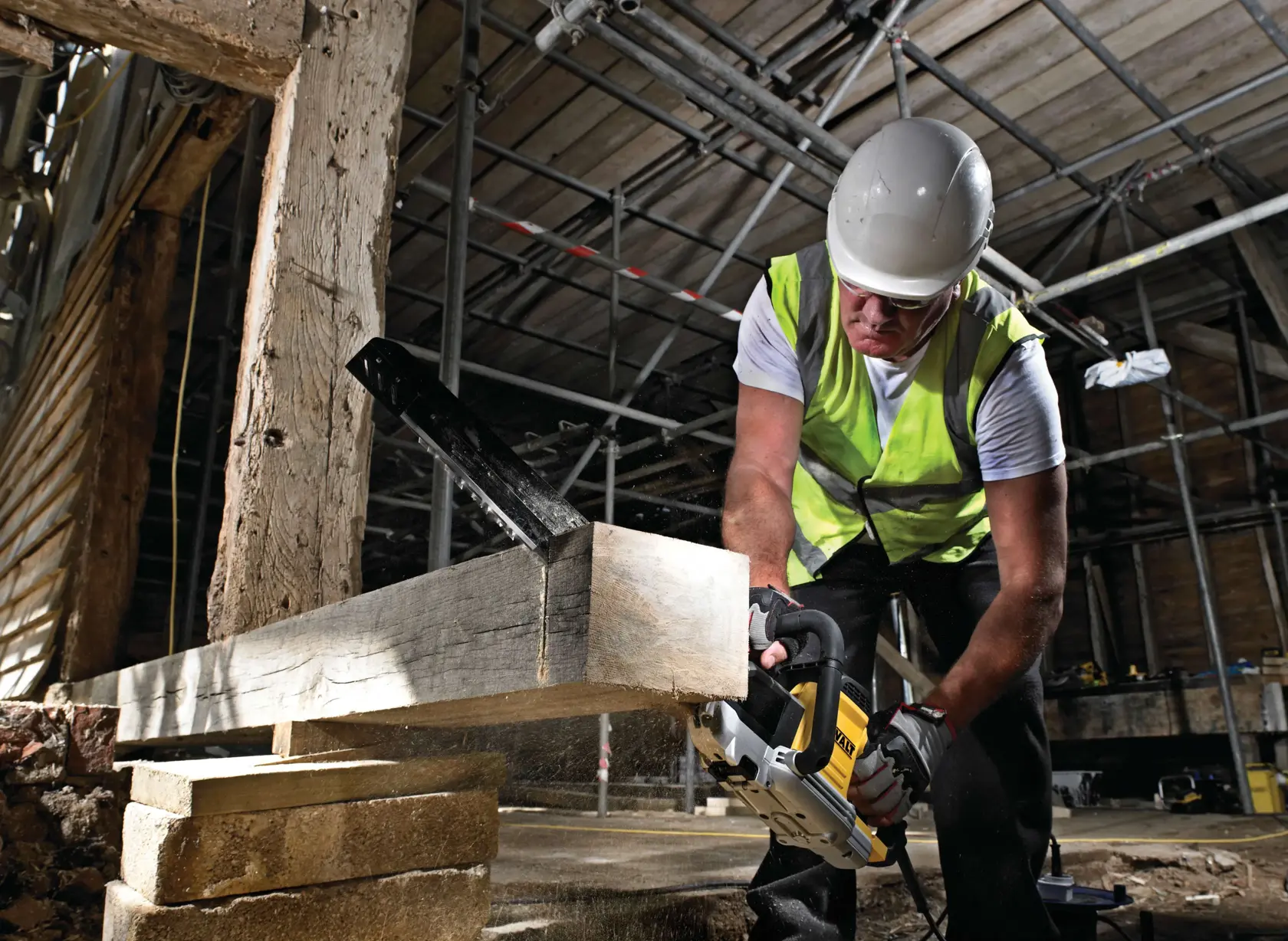 Arbeiter schneidet Holz mit DEWALT Säge auf Baustelle, trägt Sicherheitskleidung und Warnweste.