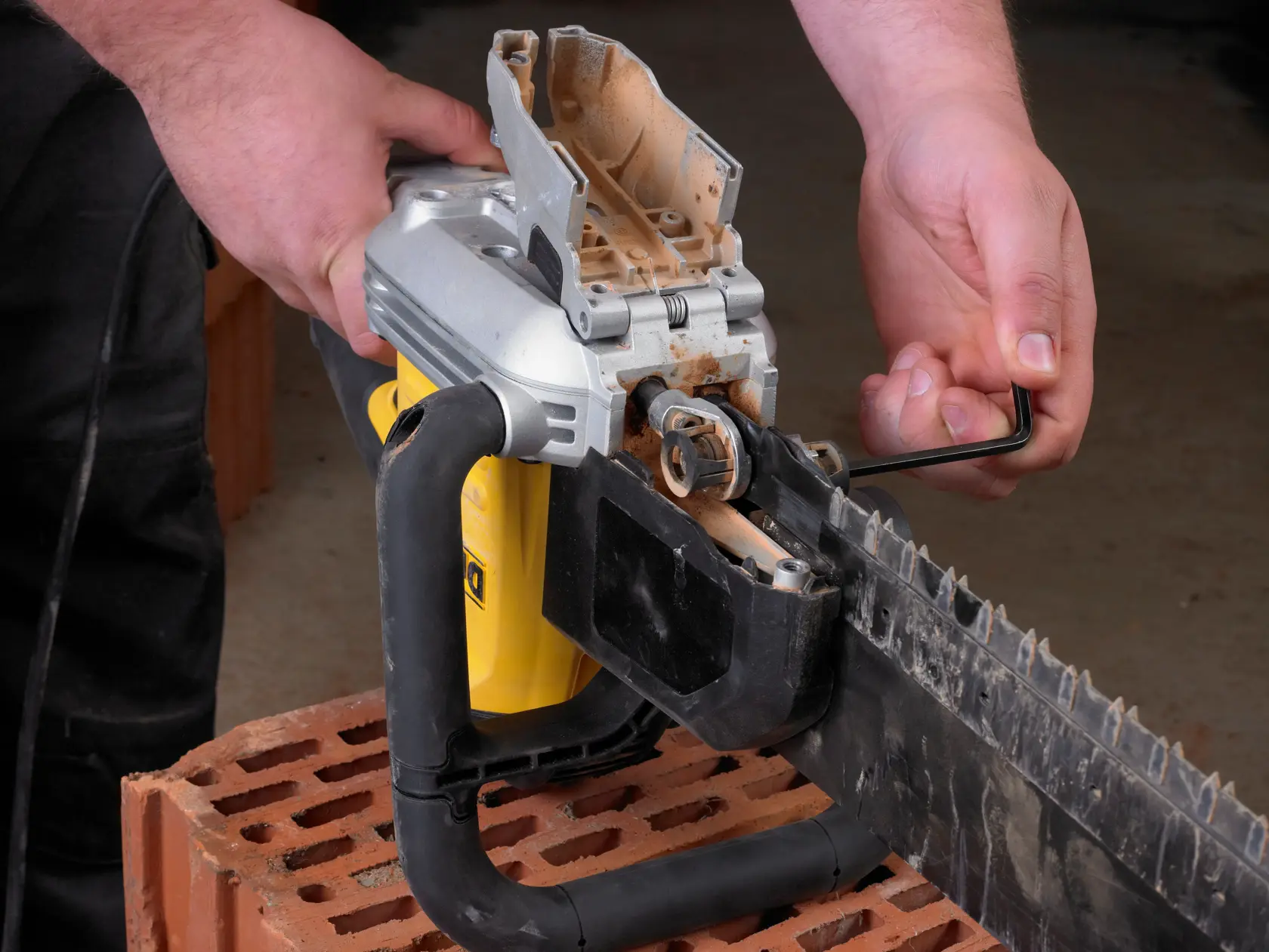 Persona ajusta una sierra DEWALT con llave hexagonal sobre un ladrillo.