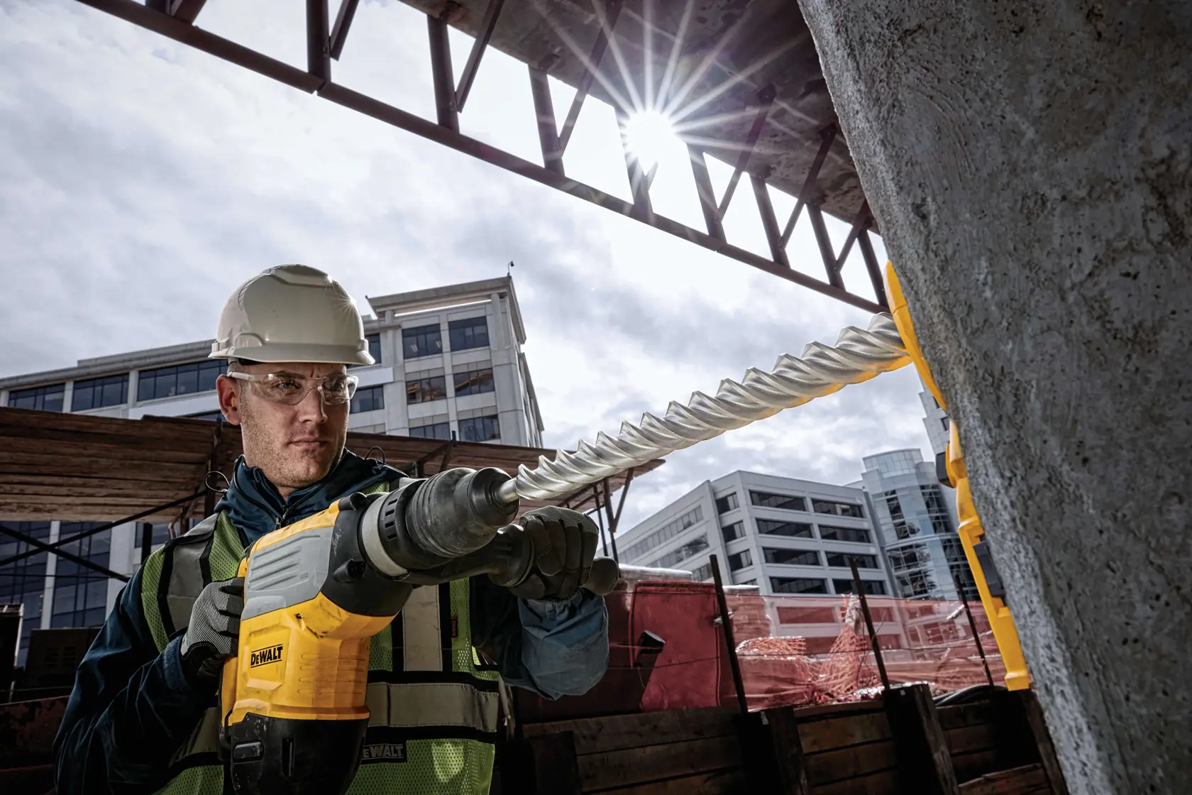 Trabajador usa broca DEWALT DT60842 en concreto en obra, con equipo de seguridad.