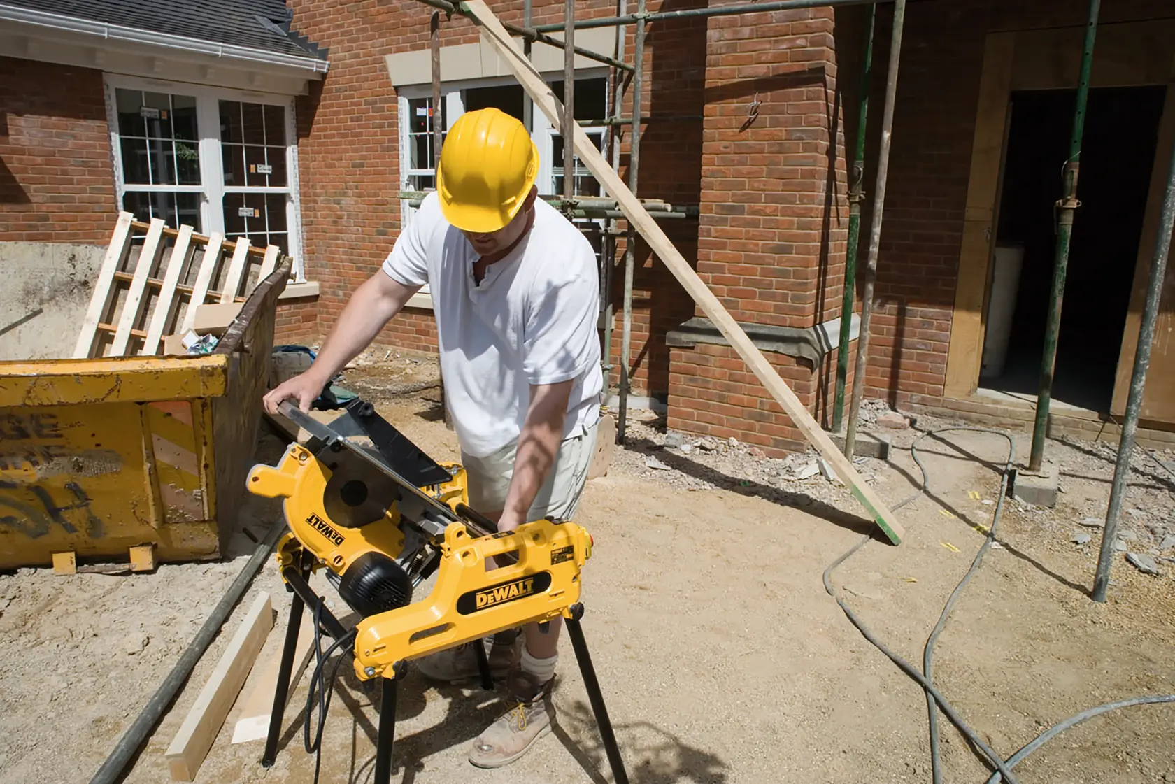 Persona utiliza la sierra DEWALT DW743N en obra exterior junto a edificio de ladrillo.