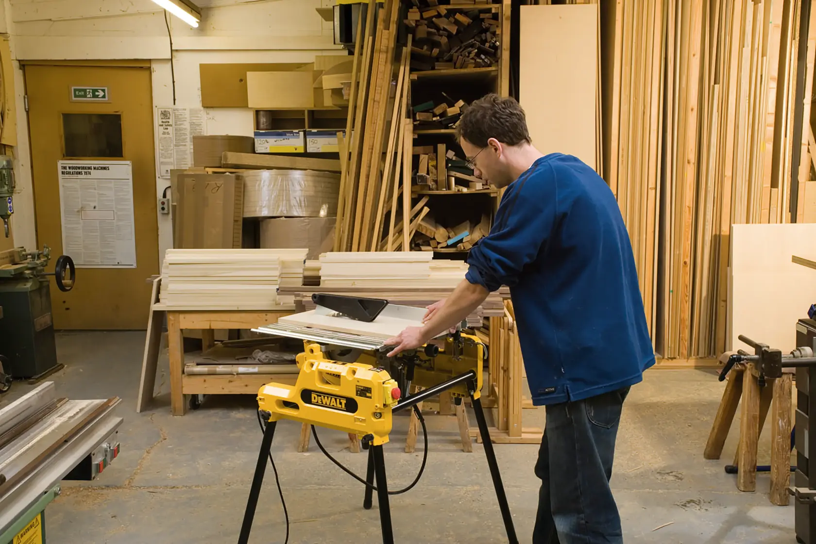 Persona usando sierra DEWALT DW743N en taller con tablas y herramientas.