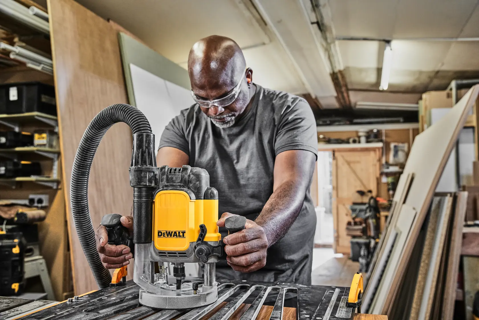 Person nutzt DEWALT Fräse DWE625-QS, DWE625 in Werkstatt. Kategorie Fotografie. Mehrere SKUs.